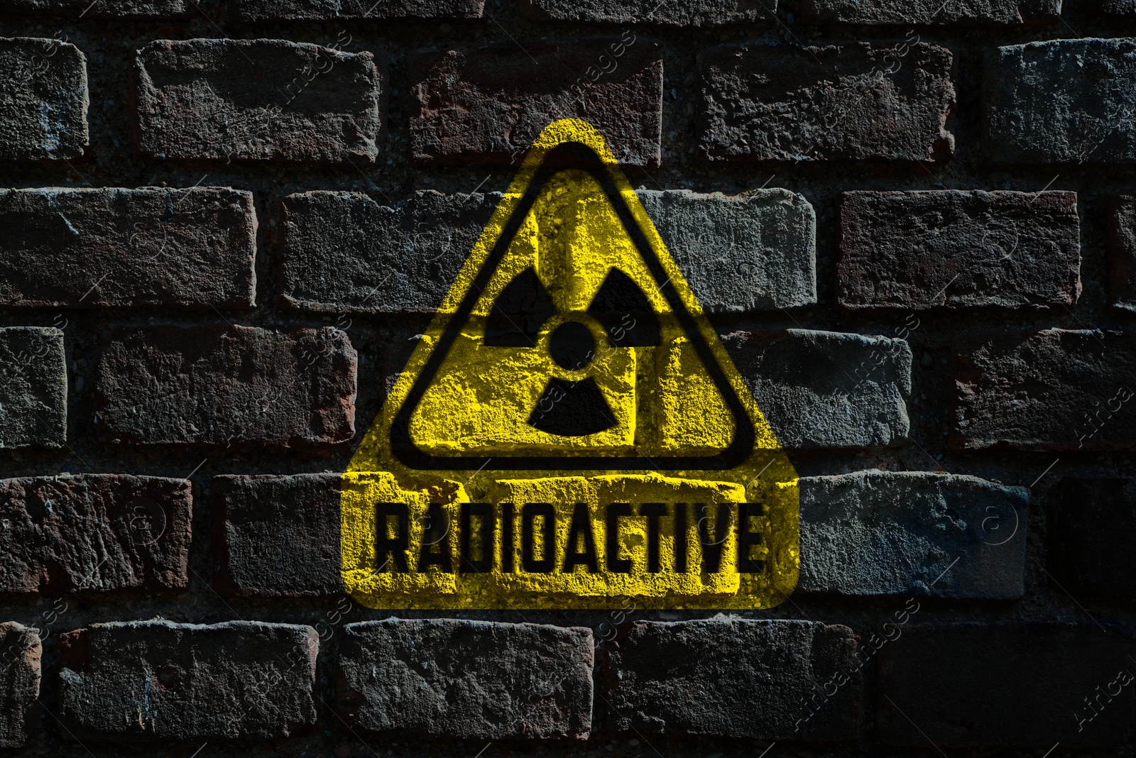 Image of Radioactive sign on dark brick wall. Hazard symbol