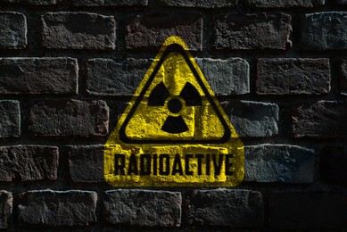 Image of Radioactive sign on dark brick wall. Hazard symbol