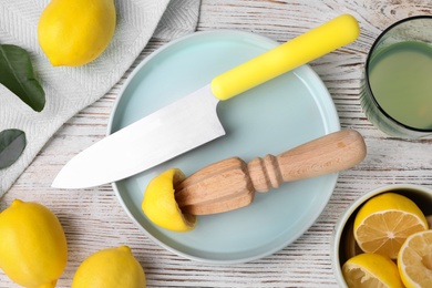 Flat lay composition with reamer and squeezed lemon on wooden table