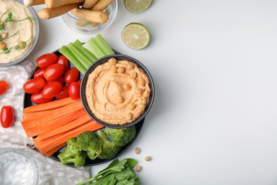 Photo of Plate with delicious hummus and fresh vegetables on white table, flat lay. Space for text