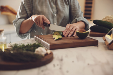 Photo of Woman cooking at table in kitchen, closeup