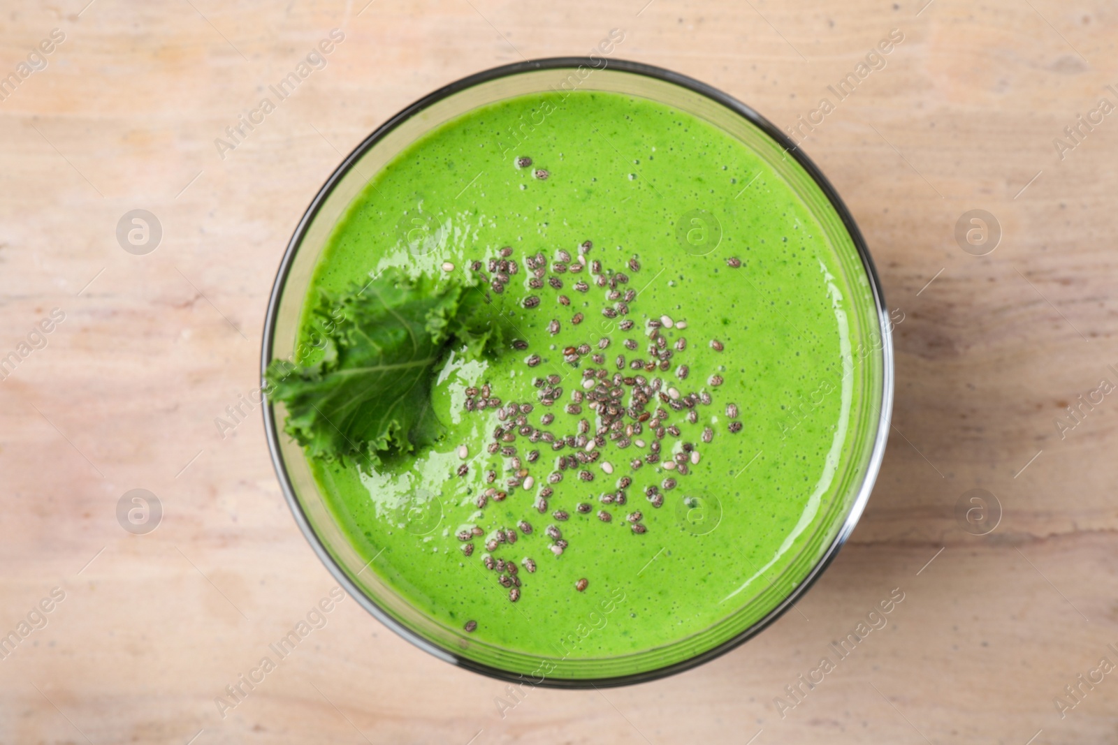 Photo of Tasty kale smoothie with chia seeds on wooden table, top view