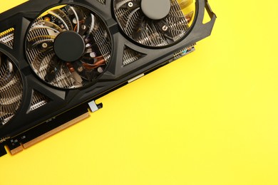 Photo of One graphics card on yellow background, top view. Space for text