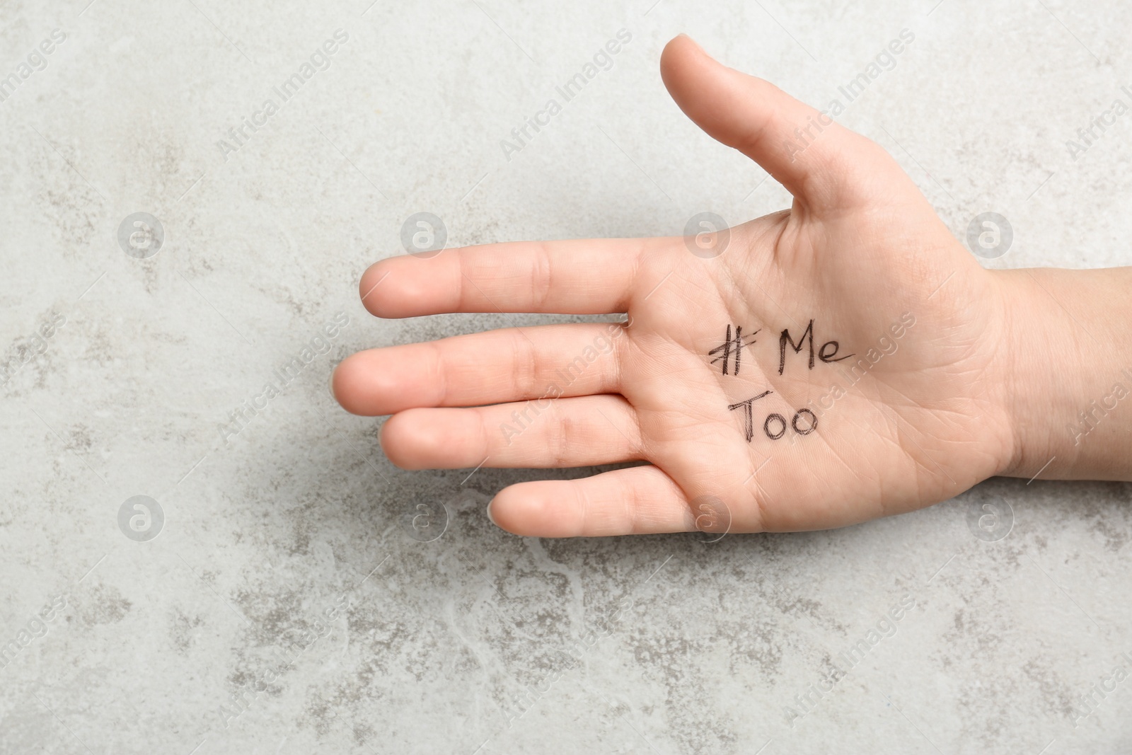 Photo of Woman showing palm with hashtag METOO on grey background, closeup. Stop sexual assault