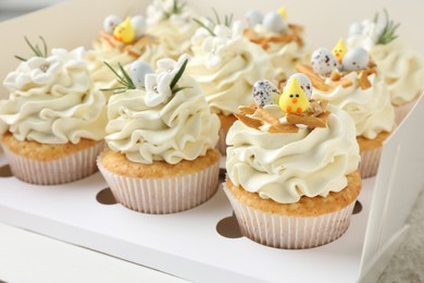 Tasty Easter cupcakes with vanilla cream in box, closeup