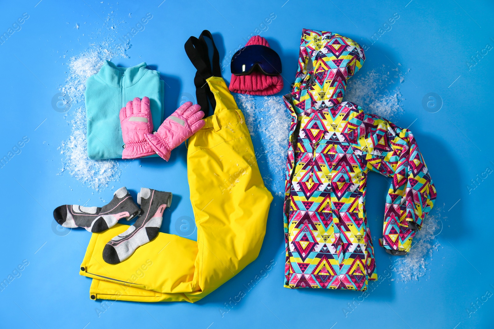 Photo of Stylish winter sport clothes on light blue background, flat lay