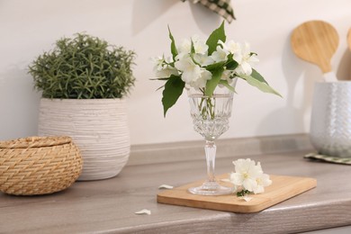 Beautiful jasmine flowers on wooden table indoors