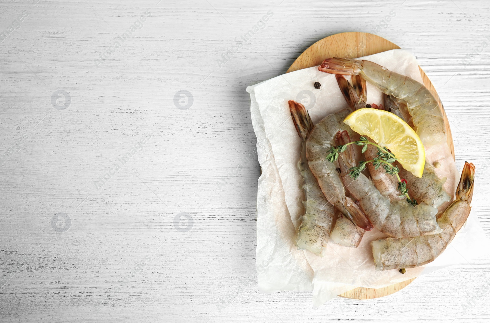 Photo of Fresh raw shrimps on white wooden table, top view. Space for text