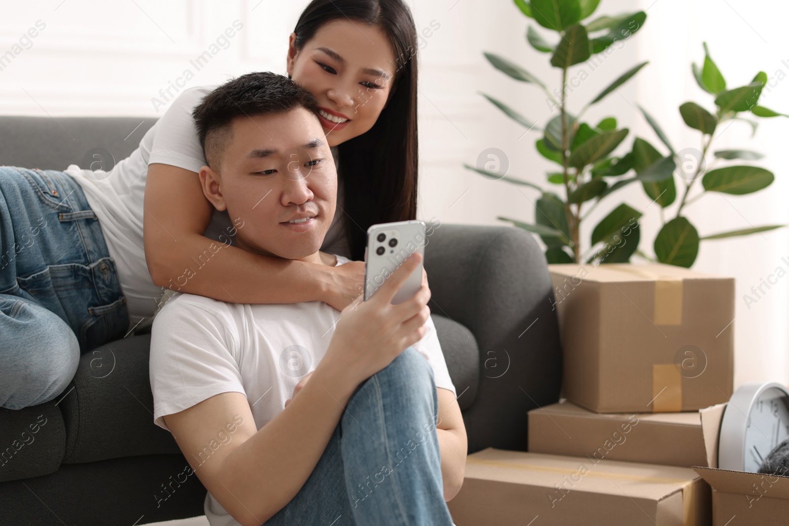 Photo of Happy couple with smartphone in their new apartment