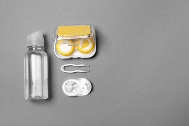 Flat lay composition with contact lenses and accessories on grey background