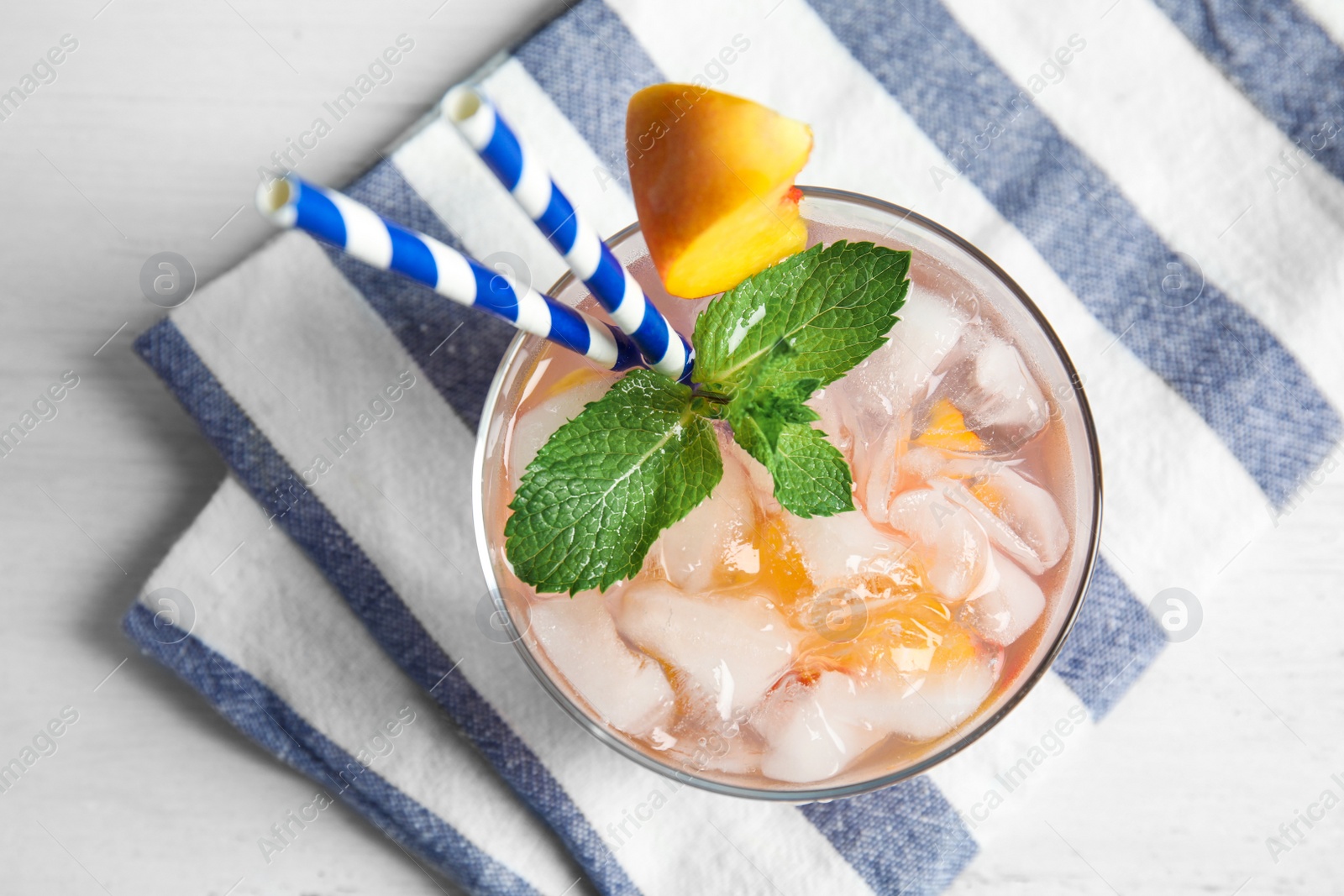 Photo of Tasty peach cocktail in glass on table, top view. Refreshing drink