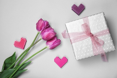 Photo of Flat lay composition with elegant gift box and tulips for Mother's Day on light background