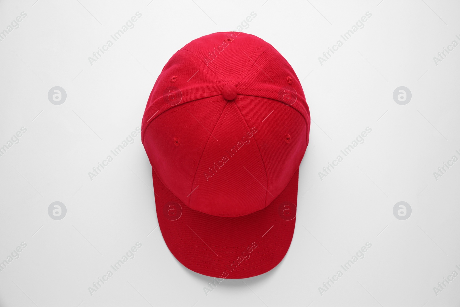 Photo of Stylish red baseball cap on white background, top view