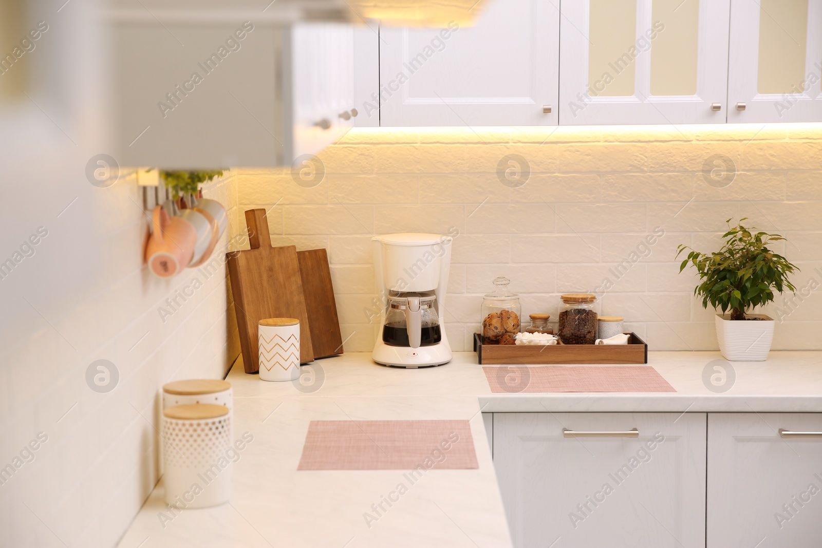 Photo of Modern coffeemaker on countertop near brick wall in kitchen