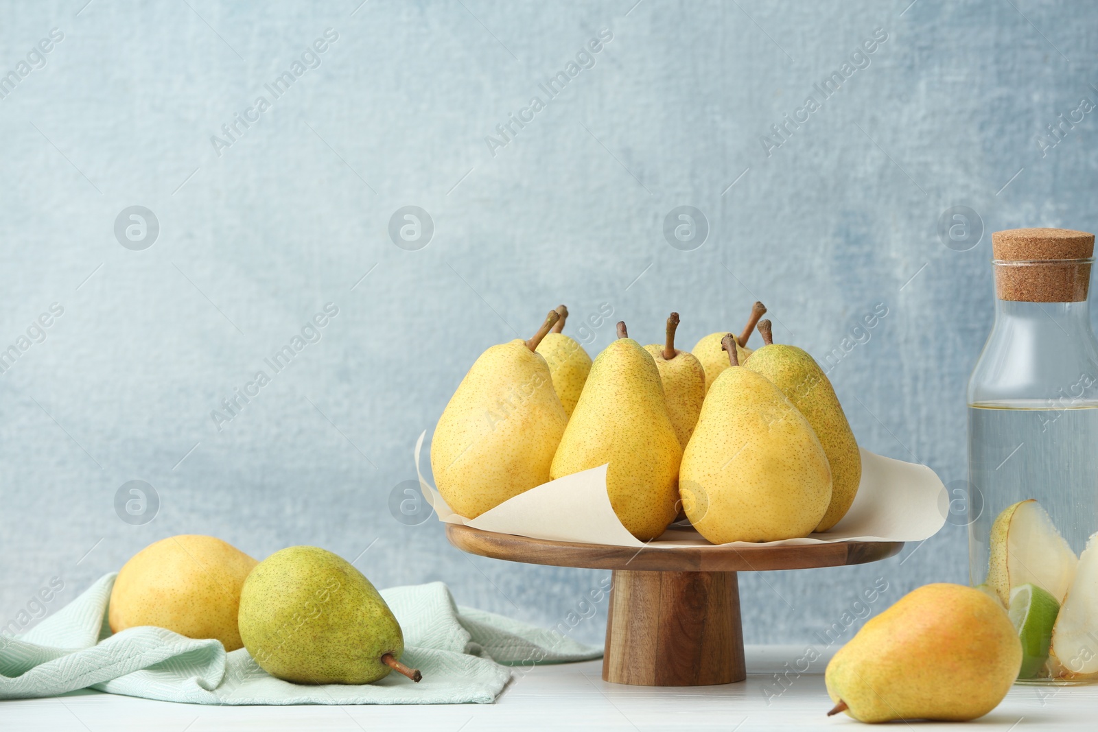 Photo of Stand with fresh ripe pears on table against color background