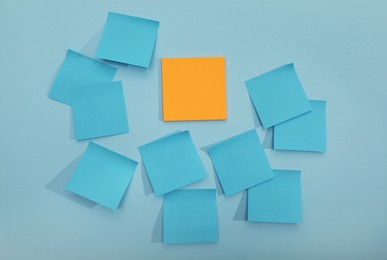 Colorful sticky notes on light blue background, flat lay