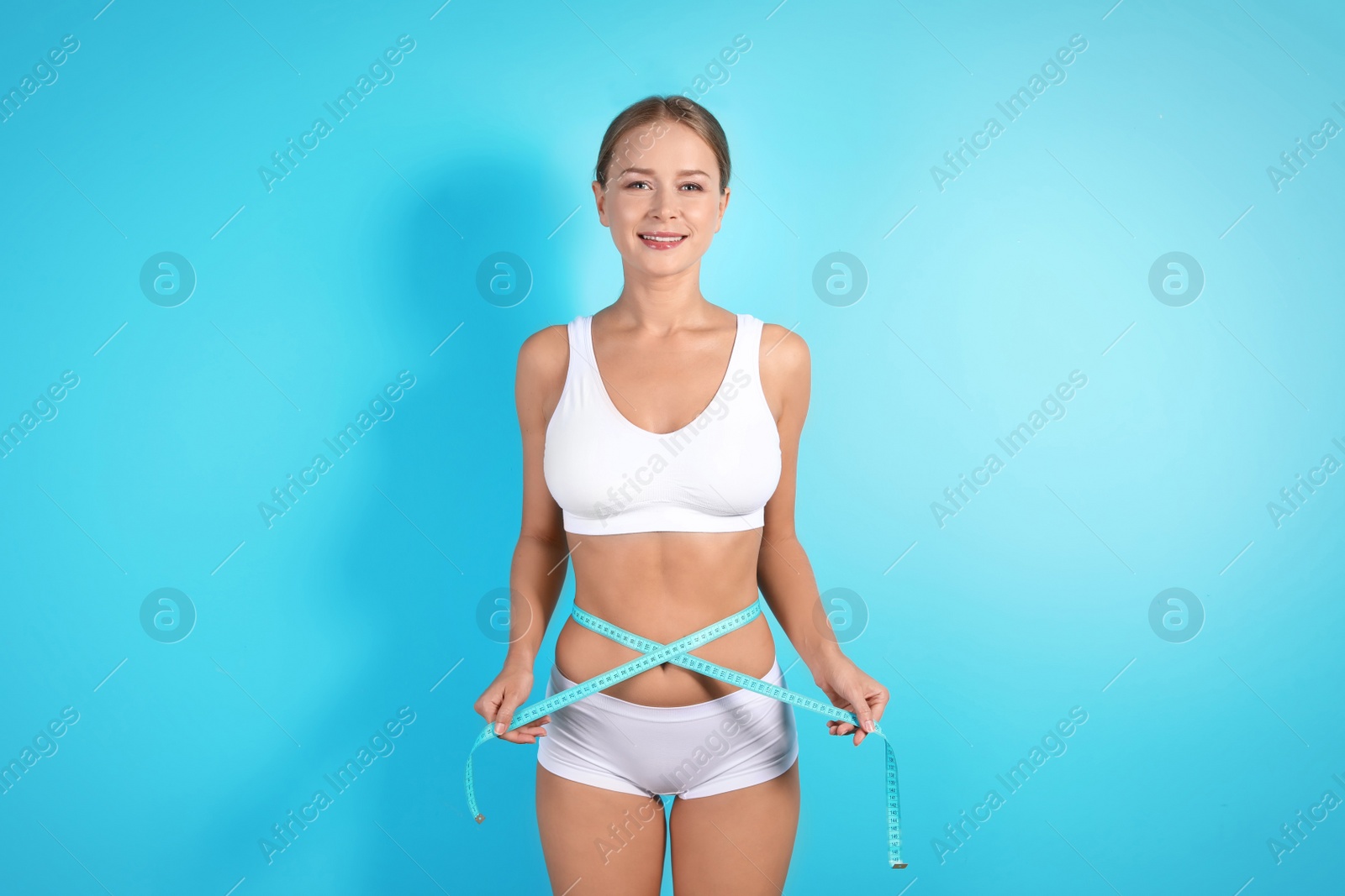 Photo of Slim woman with measuring tape on color background. Healthy diet