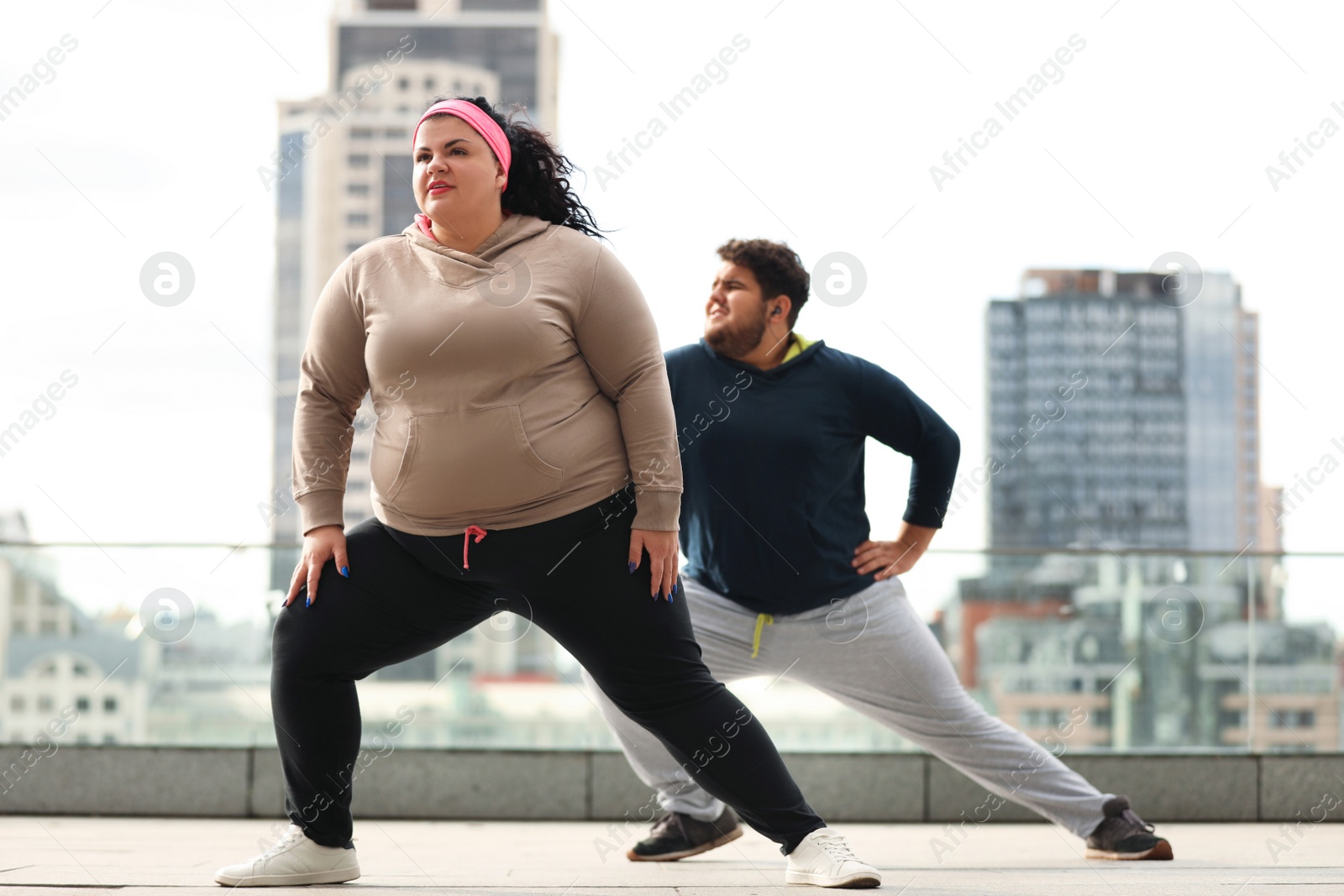 Photo of Overweight couple doing sport exercises together outdoors