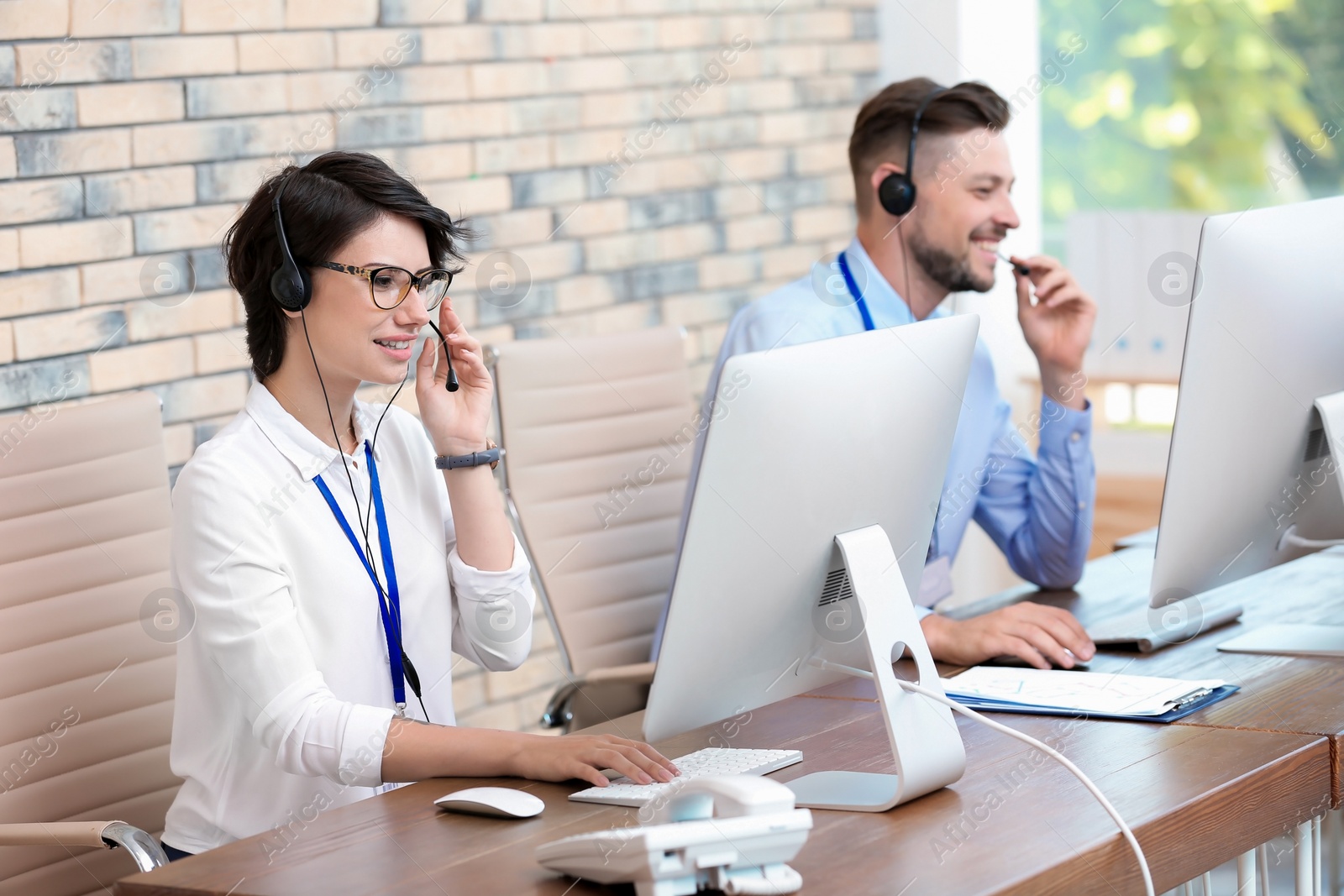 Photo of Technical support operators with headsets at workplace