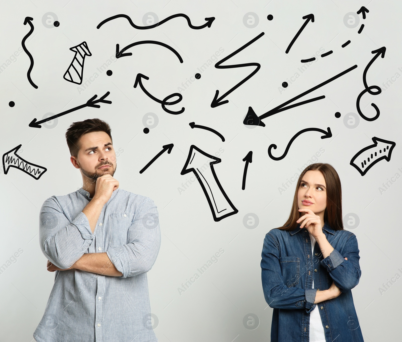 Image of Pensive couple standing near light wall with arrows 