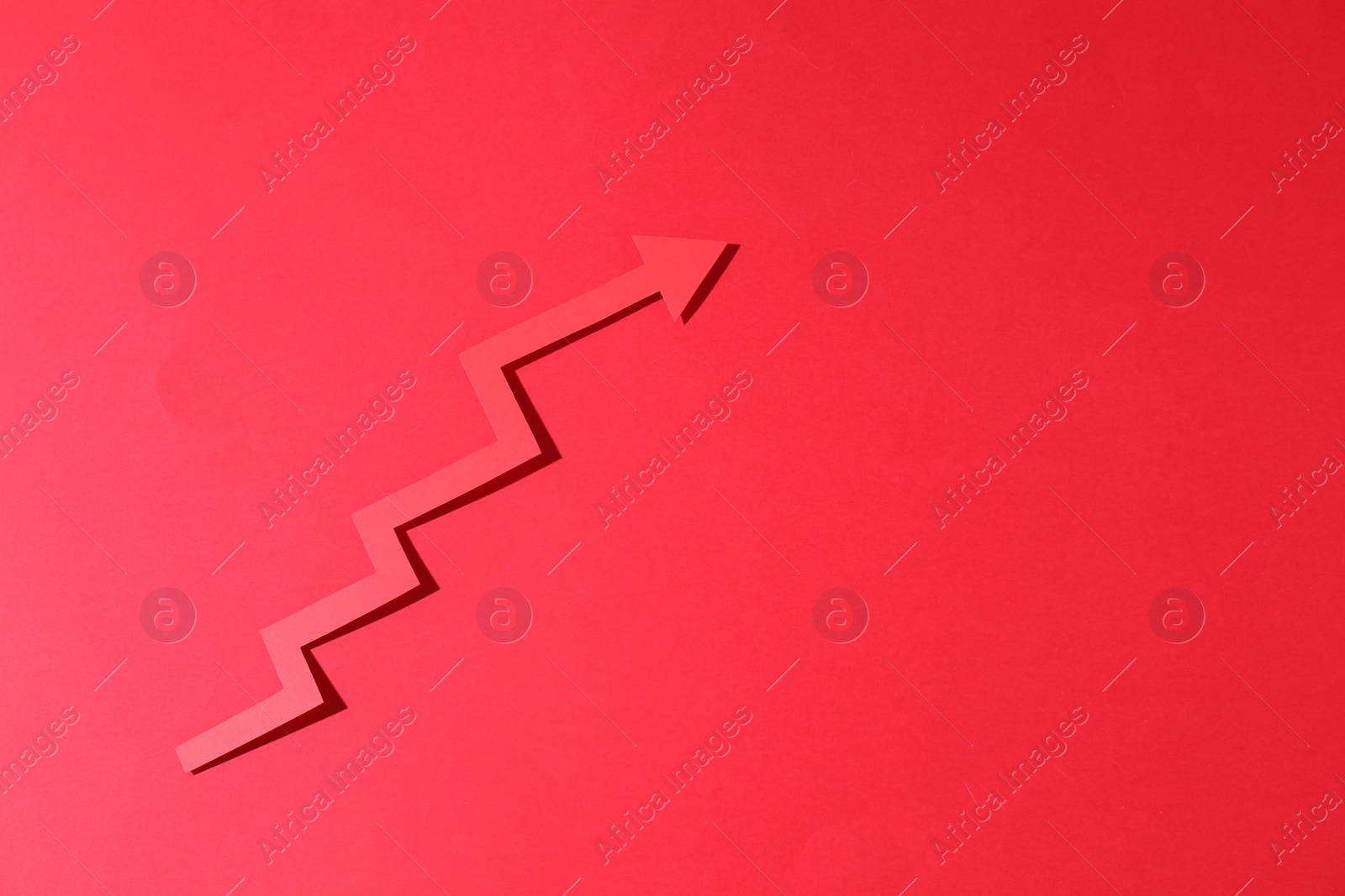 Photo of One zigzag paper arrow on red background, top view. Space for text