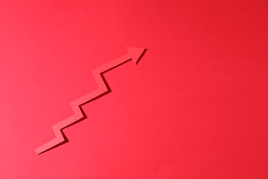 One zigzag paper arrow on red background, top view. Space for text