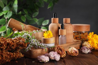 Jar, bottles of essential oils and different herbs on wooden table