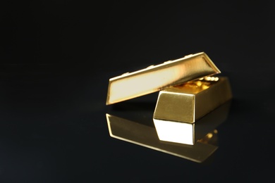 Shiny gold bars on black background. Space for text