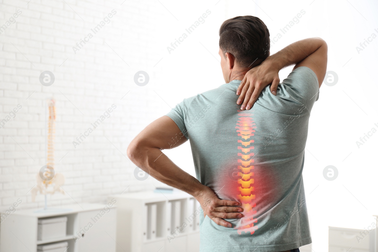 Image of Man suffering from pain in back at clinic