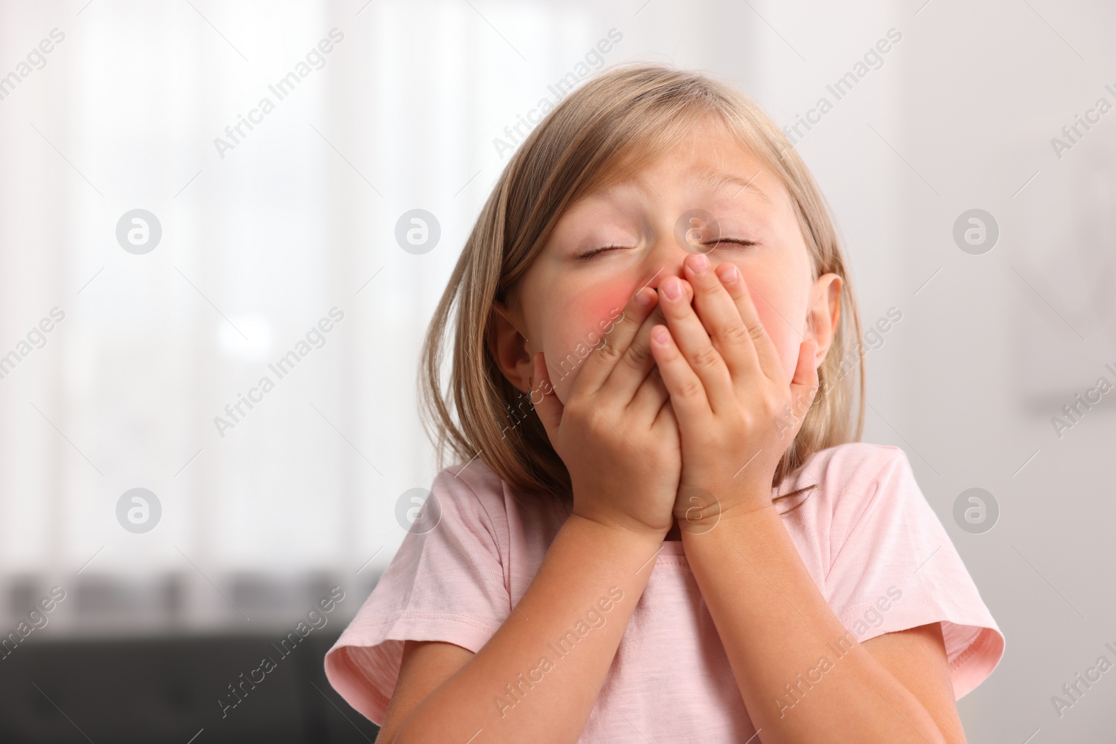 Photo of Suffering from allergy. Little girl sneezing at home, space for text