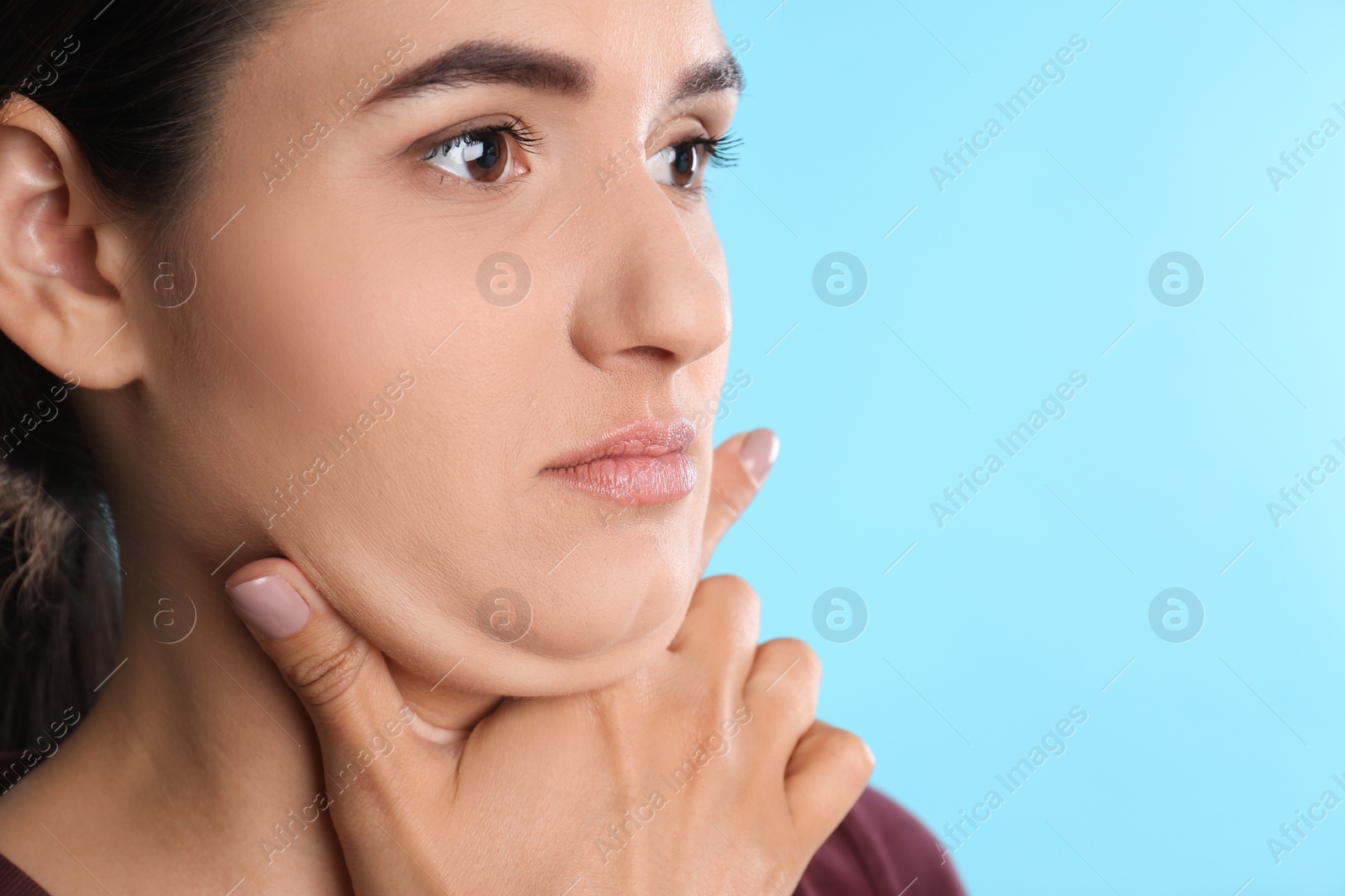 Photo of Young woman with double chin on blue background. Space for text