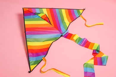Photo of Beautiful bright rainbow kite on pink background