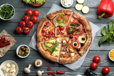 Photo of Flat lay composition with slices of different delicious pizzas on grey wooden table