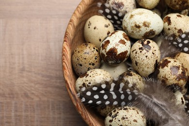 Photo of Speckled quail eggs on wooden table, closeup. Space for text