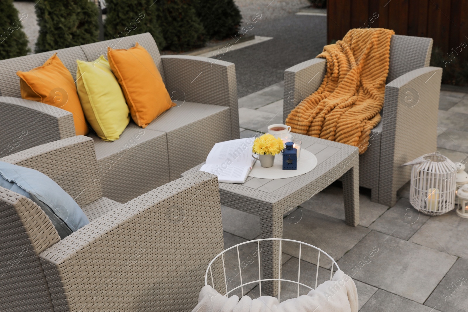 Photo of Beautiful rattan garden furniture, soft pillows and different decor elements outdoors