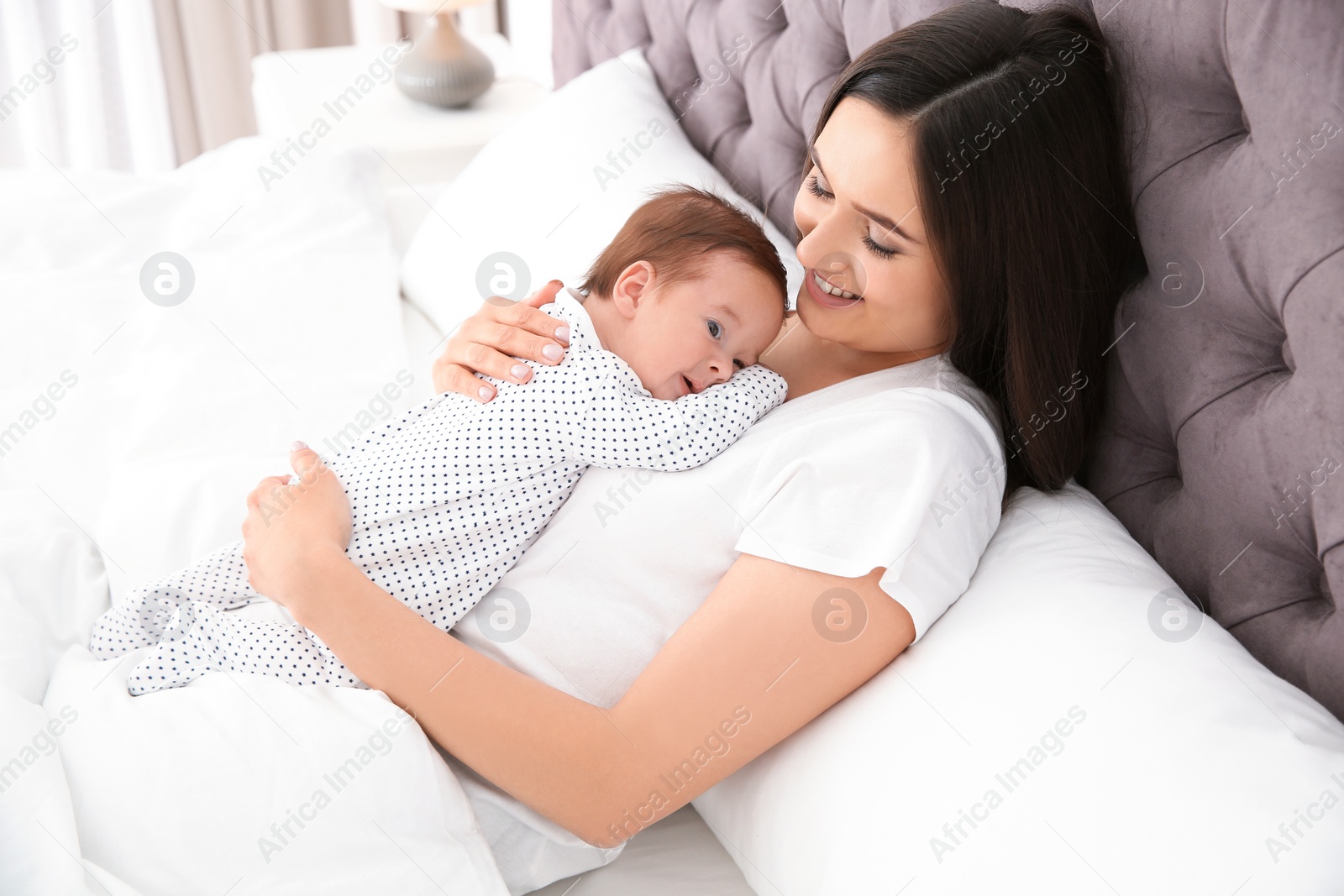 Photo of Happy woman with her cute baby on bed