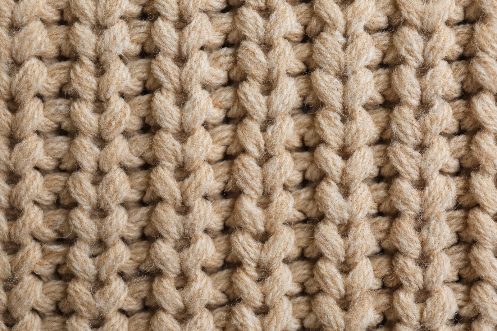 Photo of Beautiful beige knitted fabric as background, top view