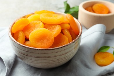 Photo of Bowl of tasty apricots and napkin on table. Dried fruits