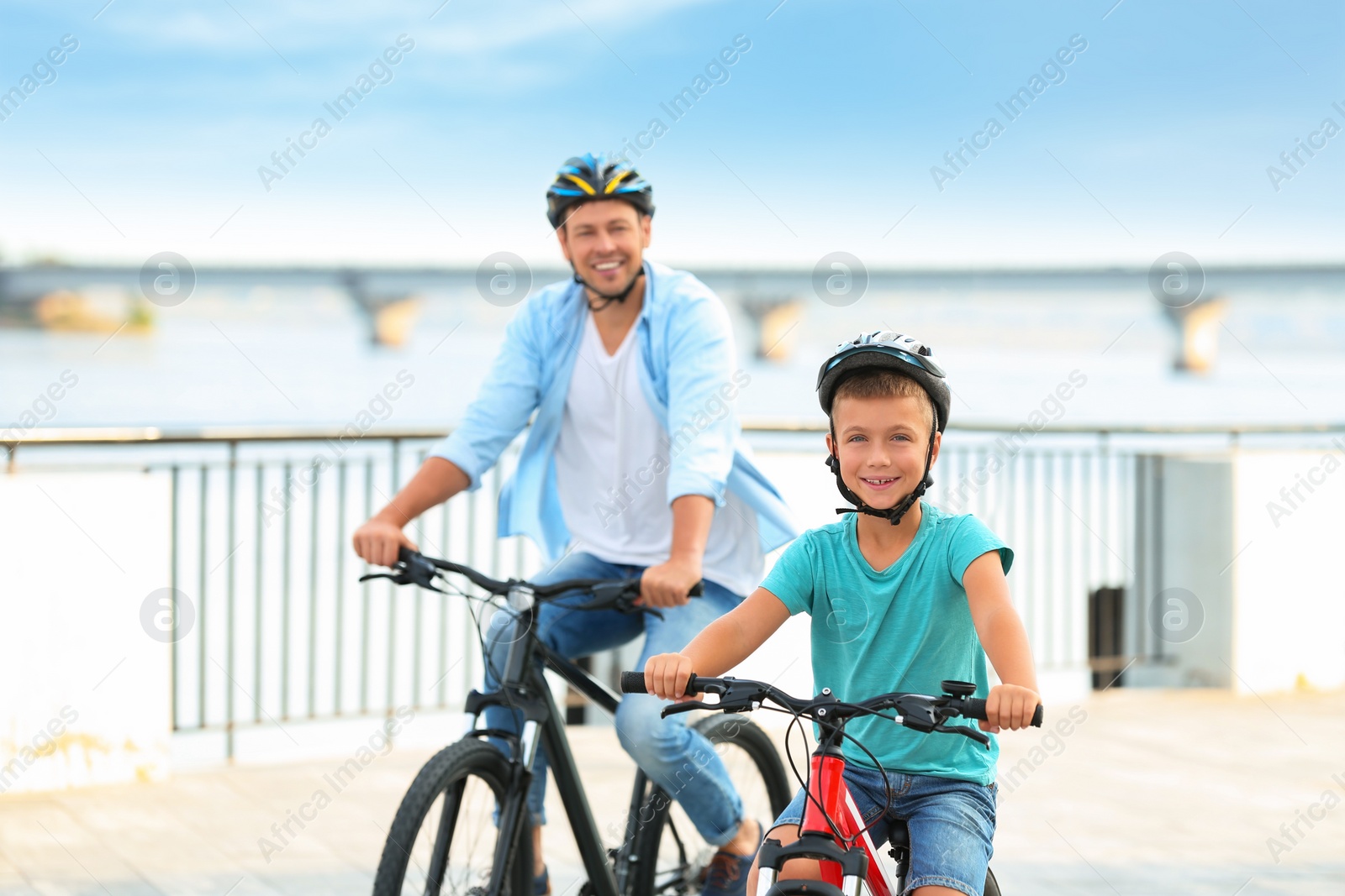 Photo of Dad and son riding bicycles together outdoors