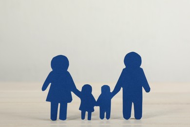 Photo of Paper family figure on white table. Child adoption concept