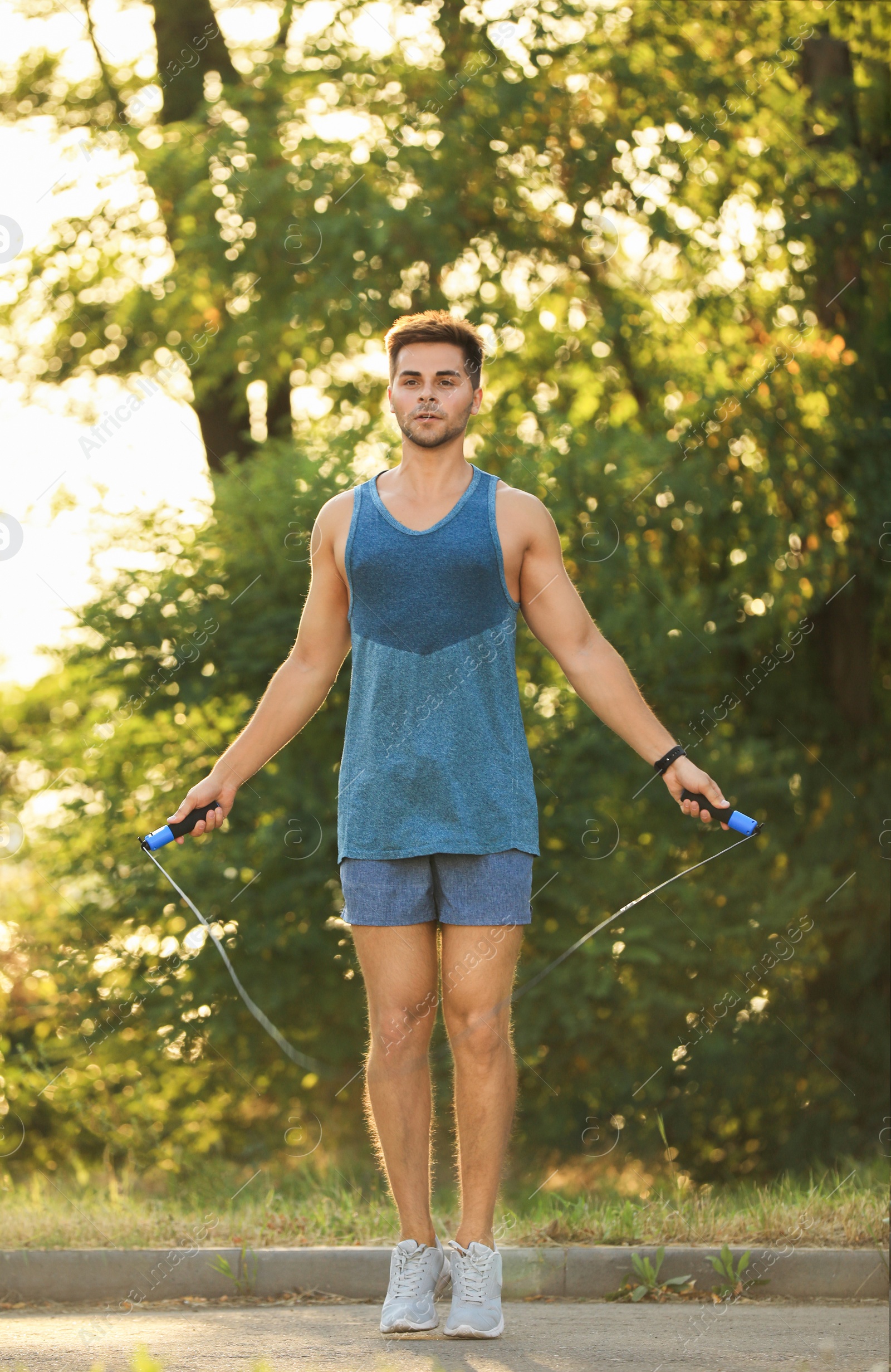 Photo of Young man training with jump rope in park