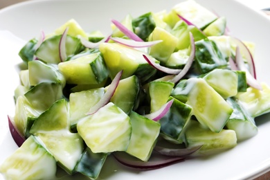 Photo of Fresh creamy cucumber salad on plate, closeup