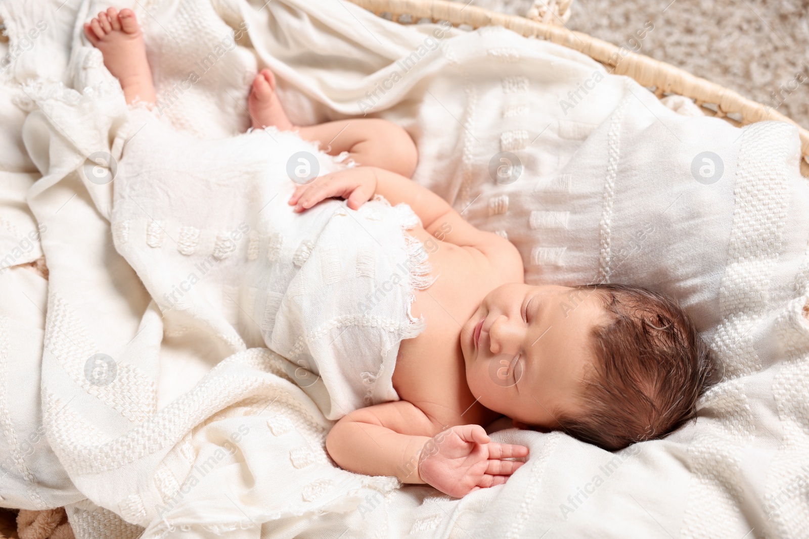 Photo of Cute newborn baby sleeping on white blanket in crib