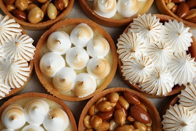 Many different tartlets on grey table, flat lay. Delicious dessert