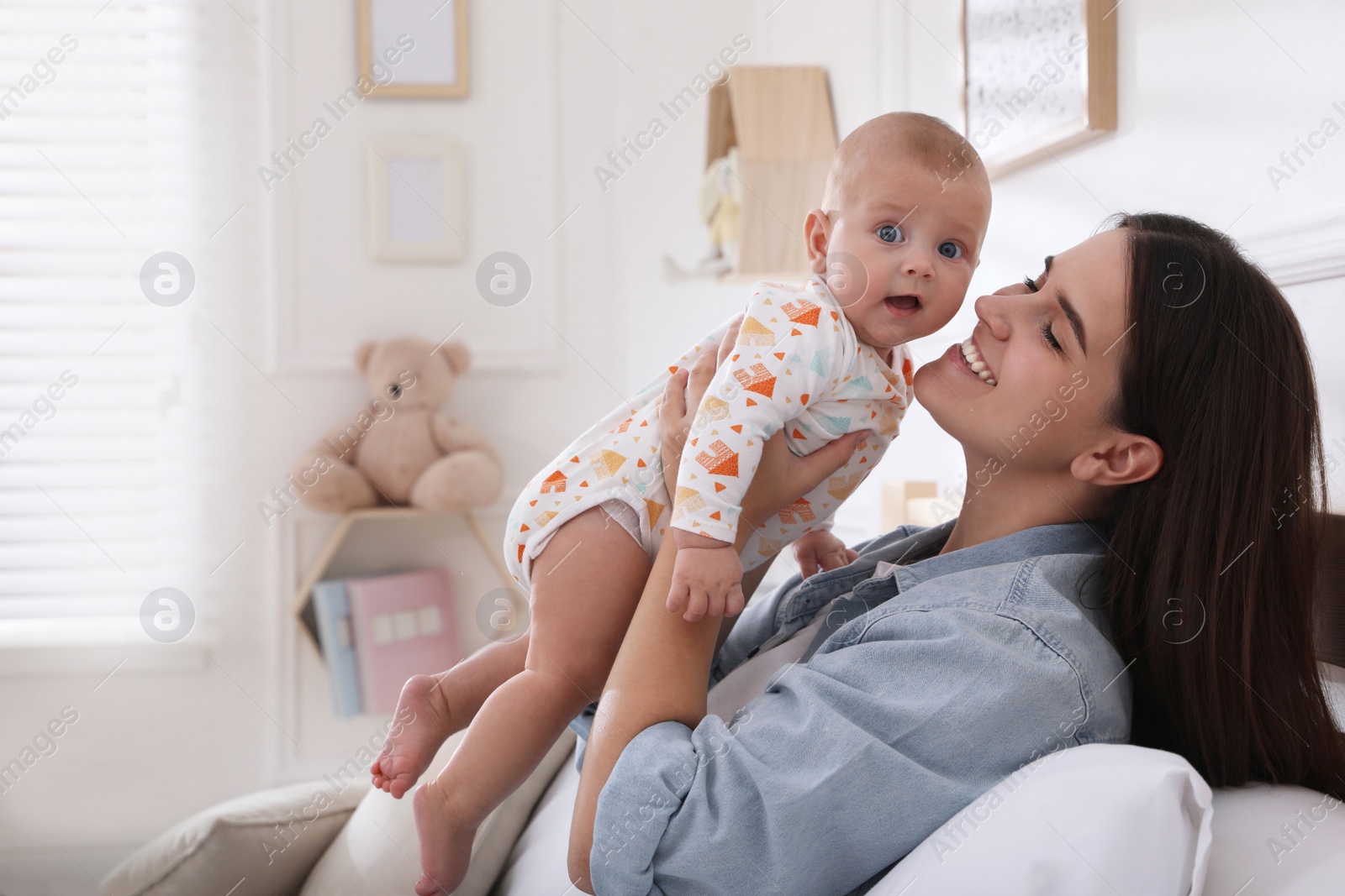 Photo of Mother with her cute baby on bed at home