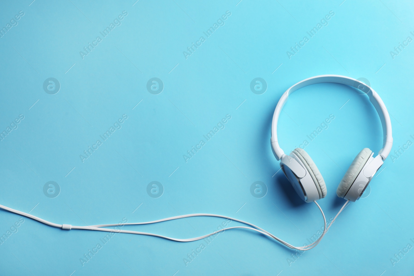 Photo of Stylish headphones on color background, top view. Space for text