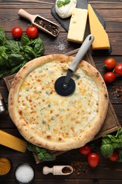 Photo of Flat lay composition with delicious cheese pizza and ingredients on wooden table