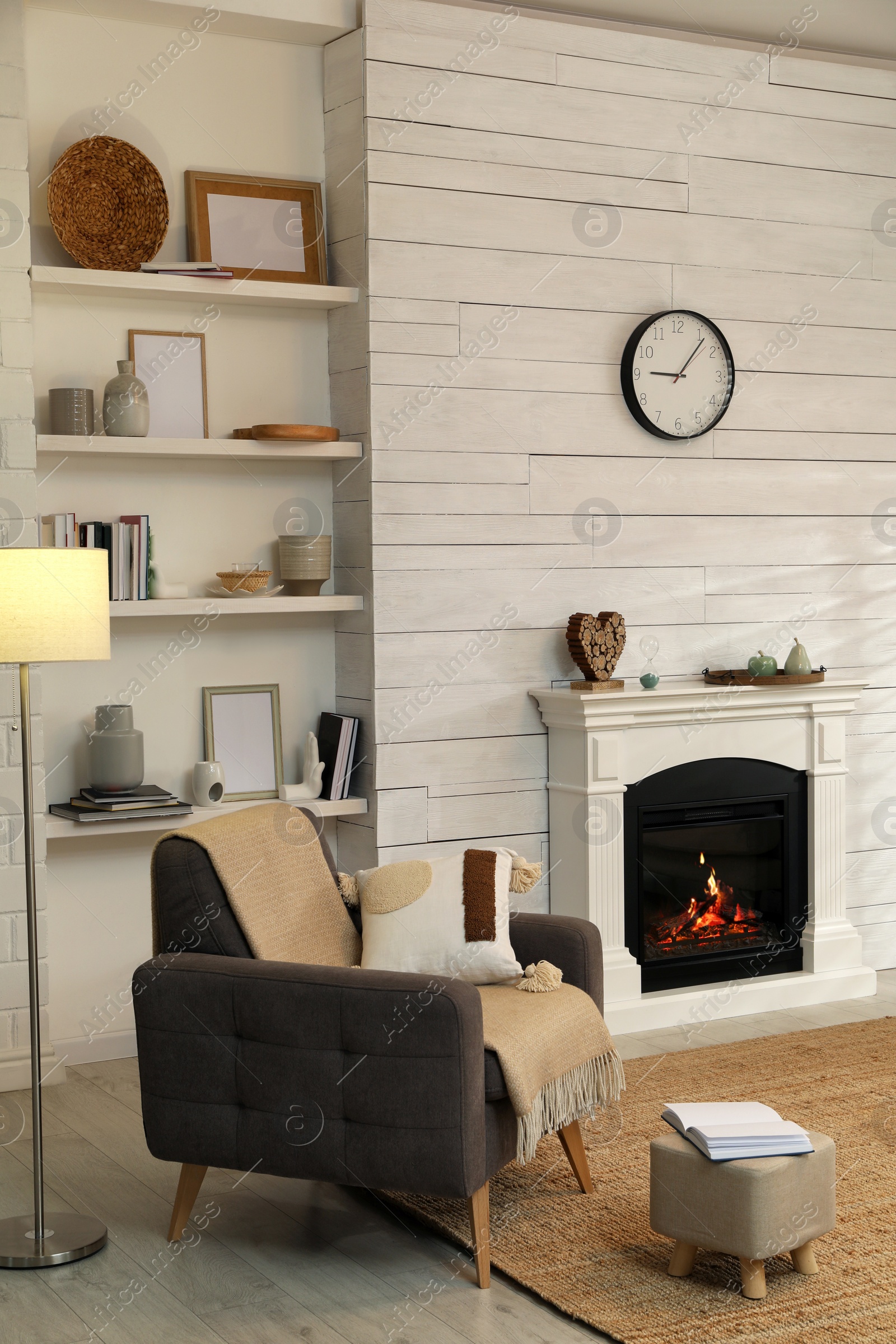 Photo of Stylish living room interior with comfortable armchair and decorative fireplace