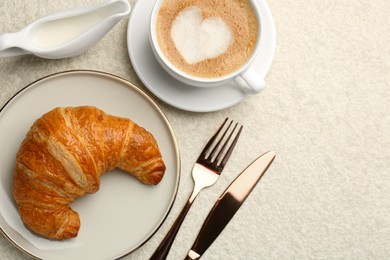 Photo of Delicious fresh croissant served with coffee on beige table, flat lay. Space for text