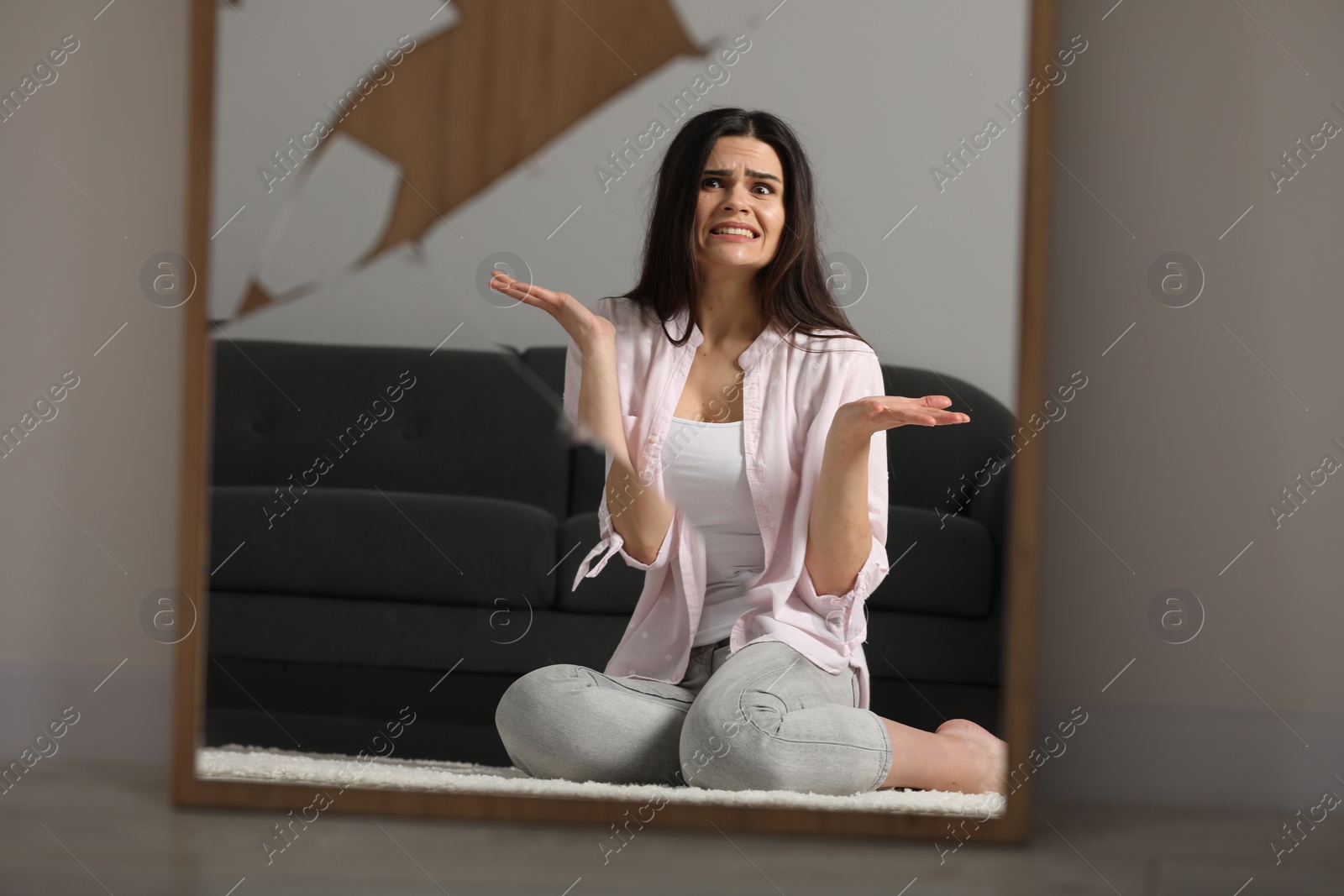 Photo of Mental problems. Emotional woman reflecting in broken mirror